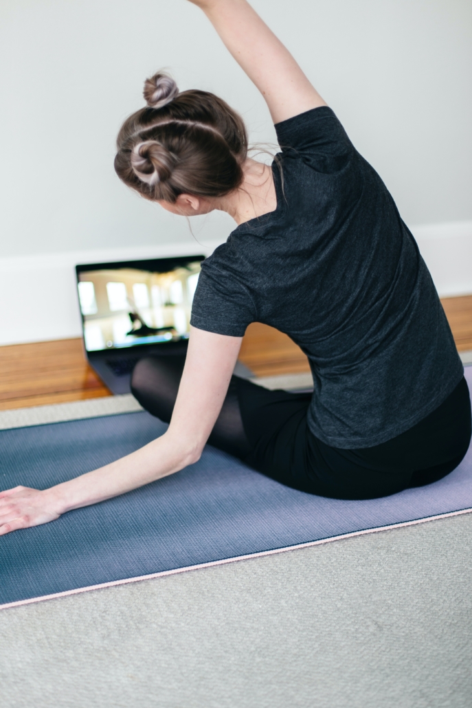 A young woman doing online yoga class