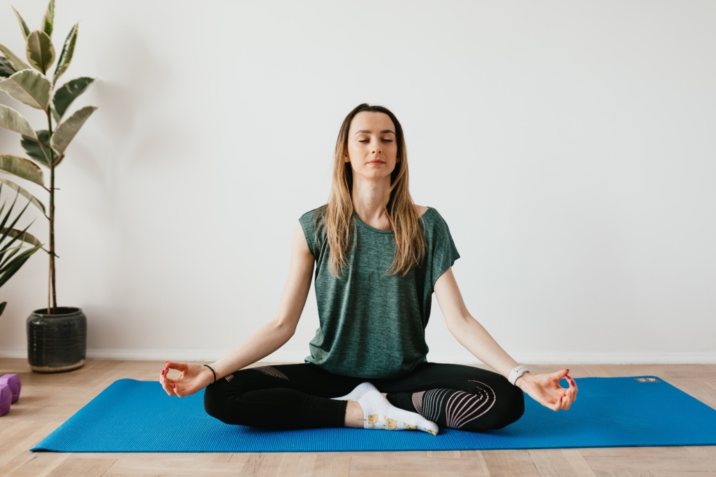 A yogi doing breathing exercises on yoga mat.